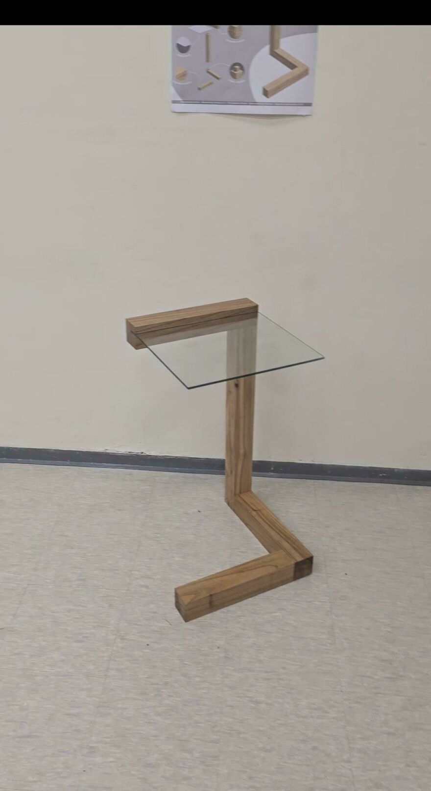 Glass and wood side table with a Z-shaped base showcasing a designer fail making it impossible to use properly.