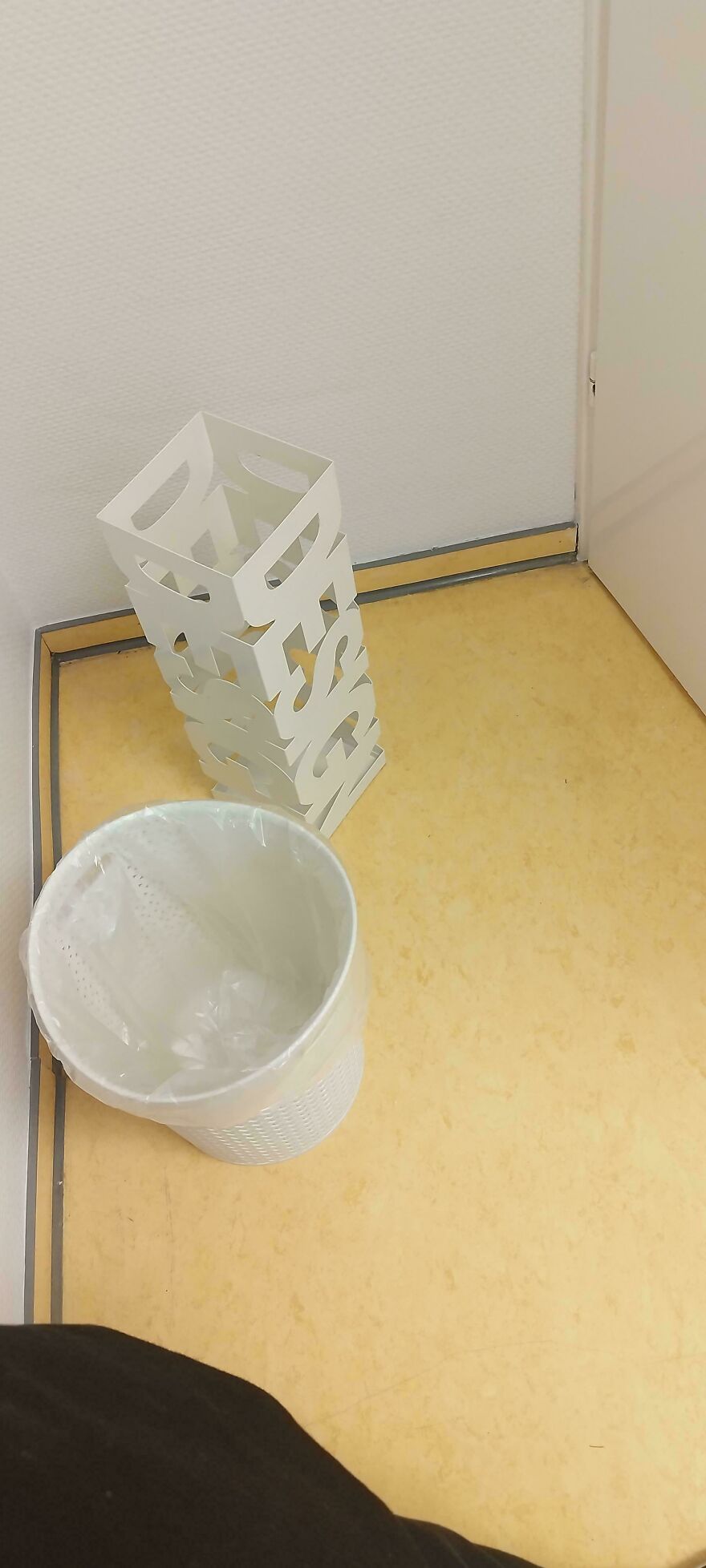 Trash bin with a decorative metal cover that makes it impossible to use, showing design gone too far and unusable concepts.