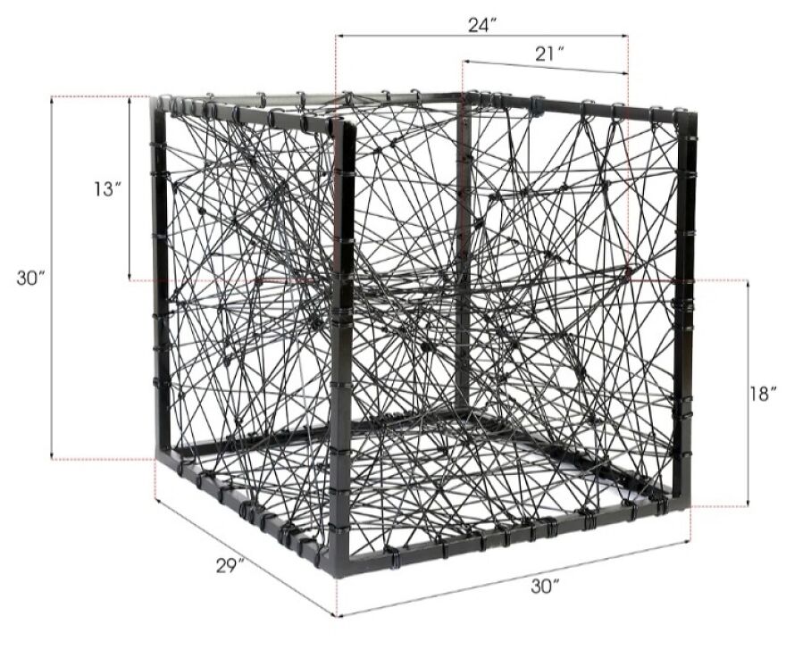Cube-shaped structure wrapped in tangled black cords, illustrating designers went too far and made things impossible to use.