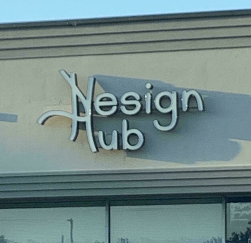 Sign for a design hub with a confusing and hard-to-read letter arrangement showcasing poor design choices.