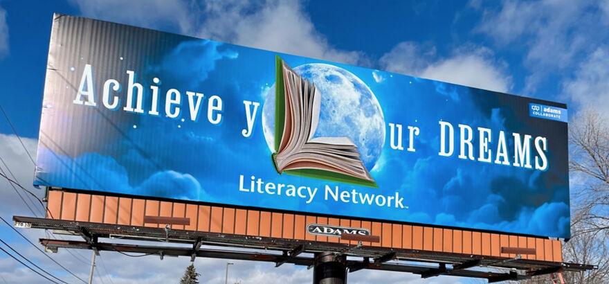 Billboard with impractical design where text is partially obscured by a large book graphic, illustrating designers going too far.