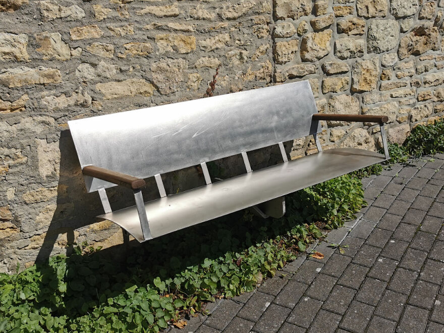 Metal bench with a sharp edge and no proper seating, an example of designers going too far in usability.