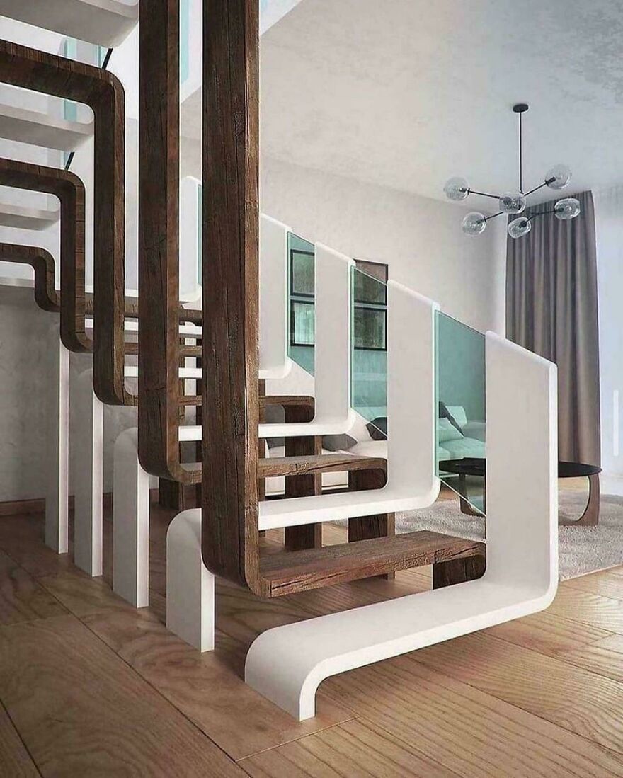 Modern staircase with impossible-to-use design featuring wooden and white geometric steps and glass panels in a living space.