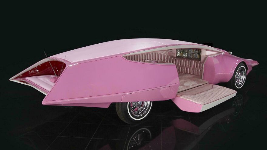 Futuristic pink car with an unusual door design making it impossible to use comfortably and efficiently.