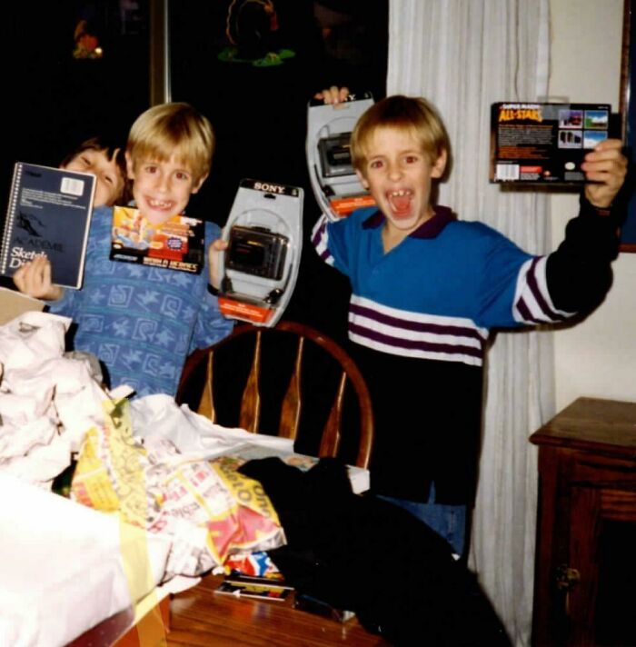 Three excited children holding up retro toys and games, capturing a hilariously awkward childhood moment.