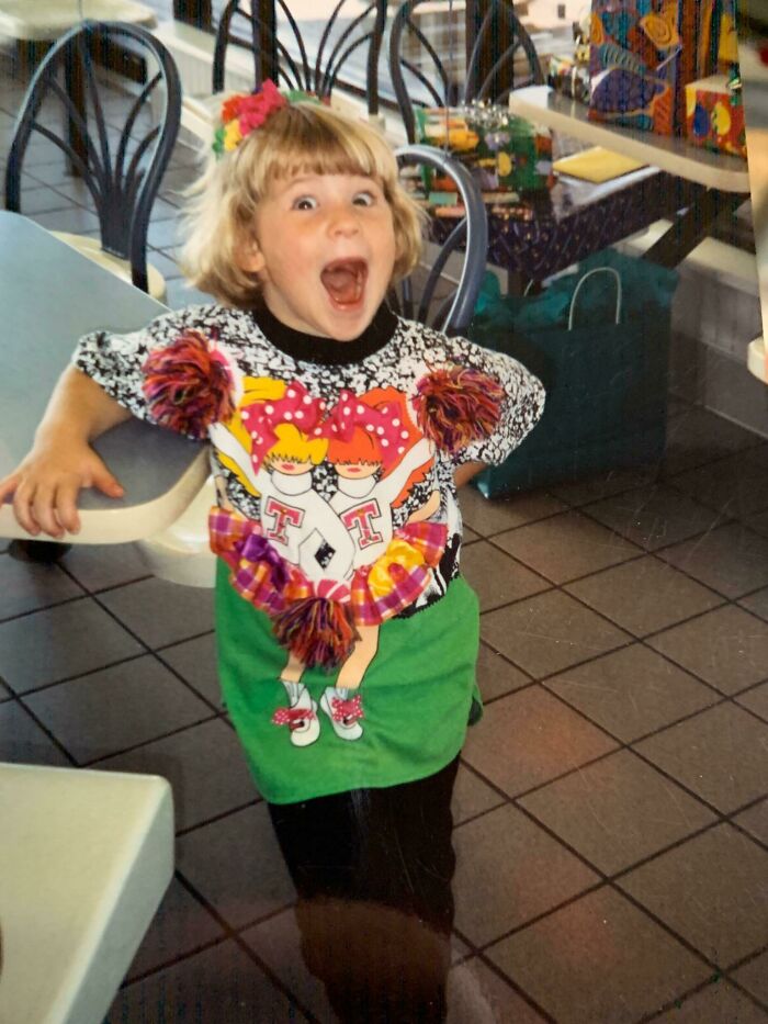 Child in a colorful, awkward outfit making a funny face, one of the hilariously awkward childhood pics shared online.