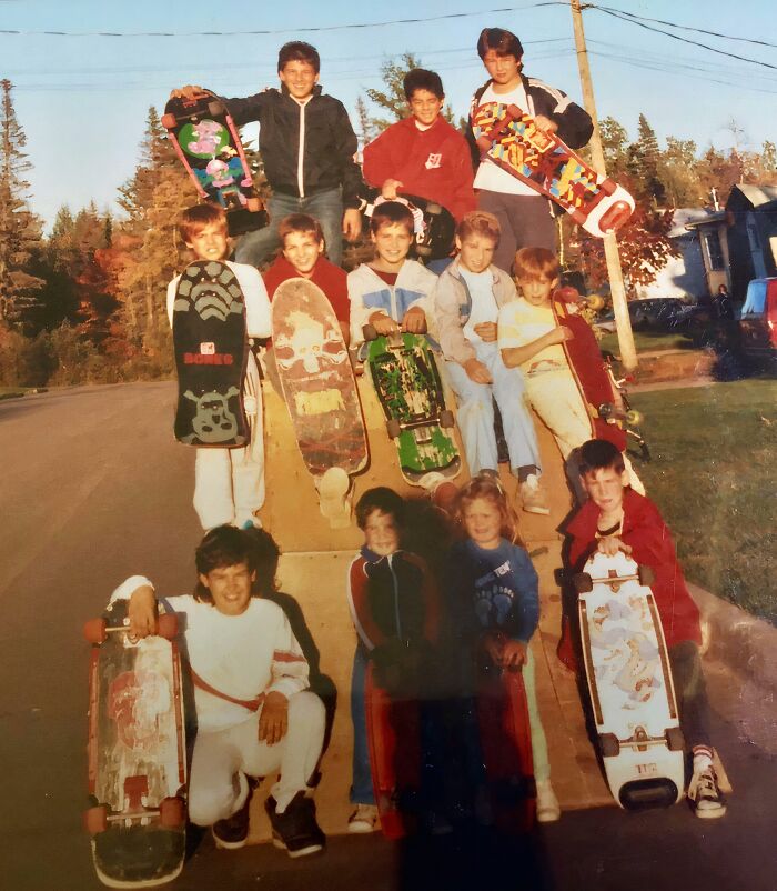 Group of kids holding skateboards on a ramp outdoors, capturing hilariously awkward childhood moments.
