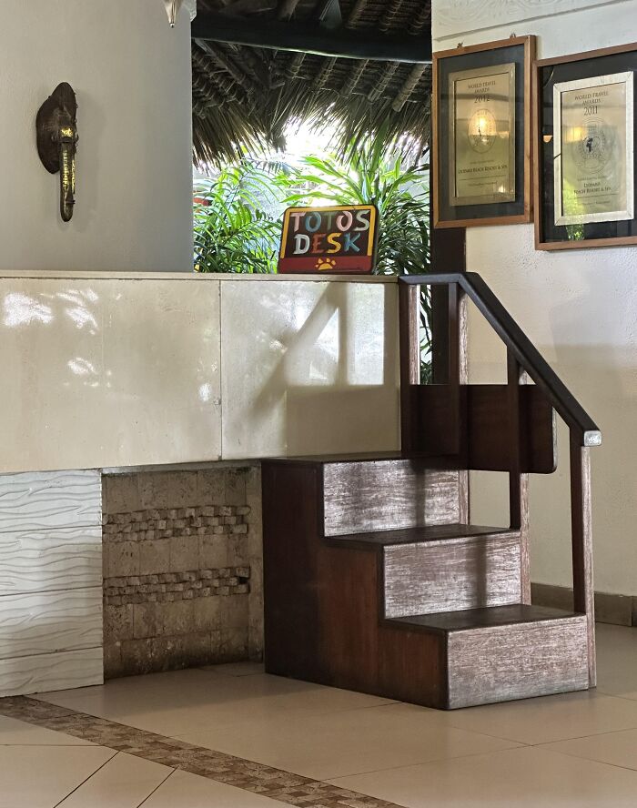 Small wooden stairs with railing leading to a desk labeled "Toto's Desk," showcasing a genius problem-solving idea.