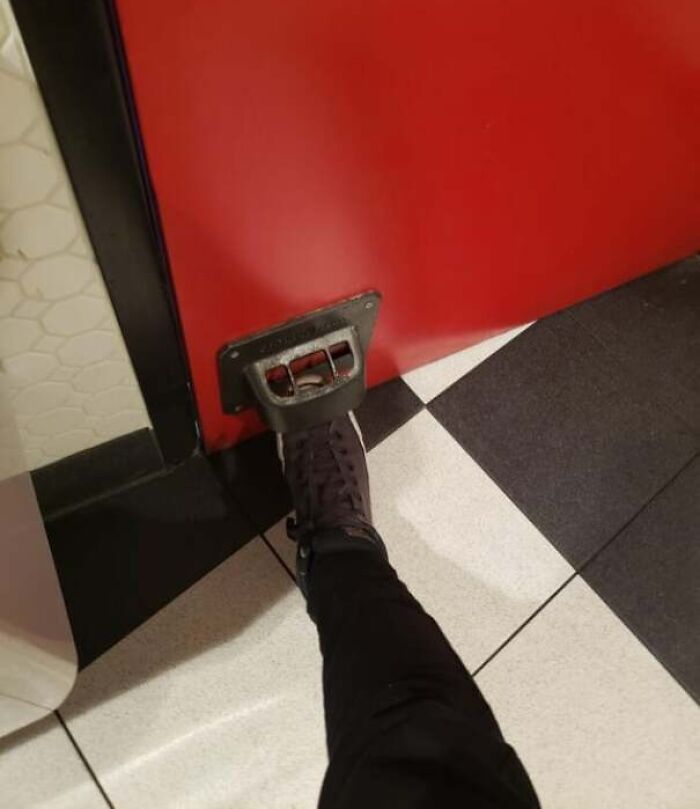 Foot pedal attached to a red door for hands-free opening, showcasing a genius solution to an annoying problem.