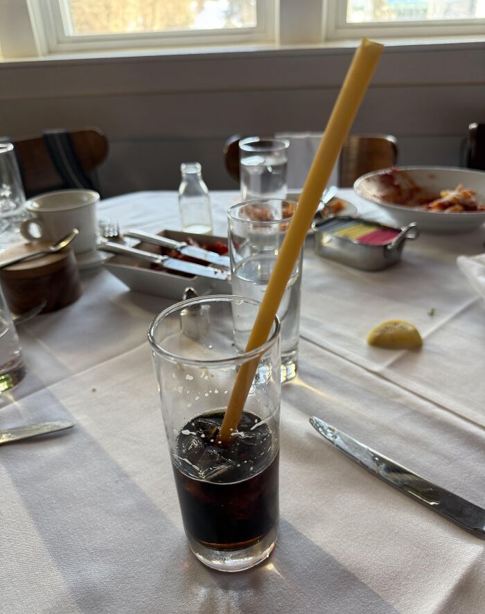 Glass of soda with straw made from a stick of uncooked spaghetti showing a surprisingly genius idea to solve an annoying problem