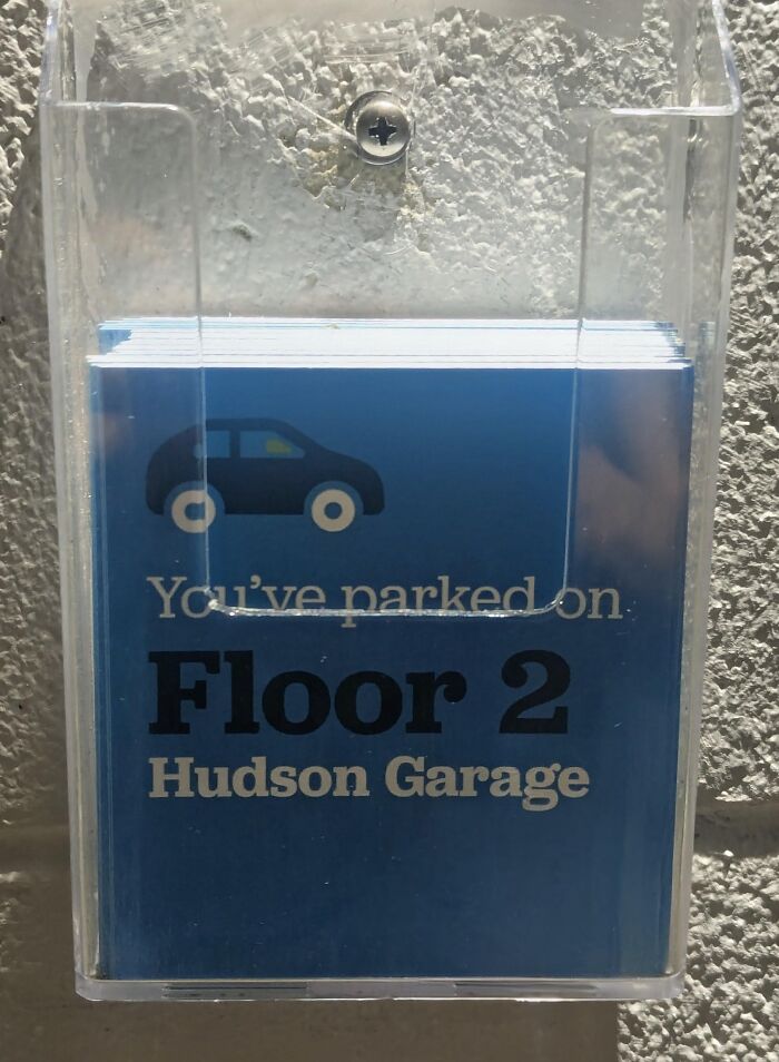 Plastic holder with blue parking reminder cards showing floor number and garage name, a clever idea for organized parking.