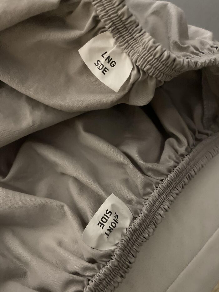 Tags inside fitted sheets labeled “long side” and “short side” showing a simple genius idea solving an annoying problem.