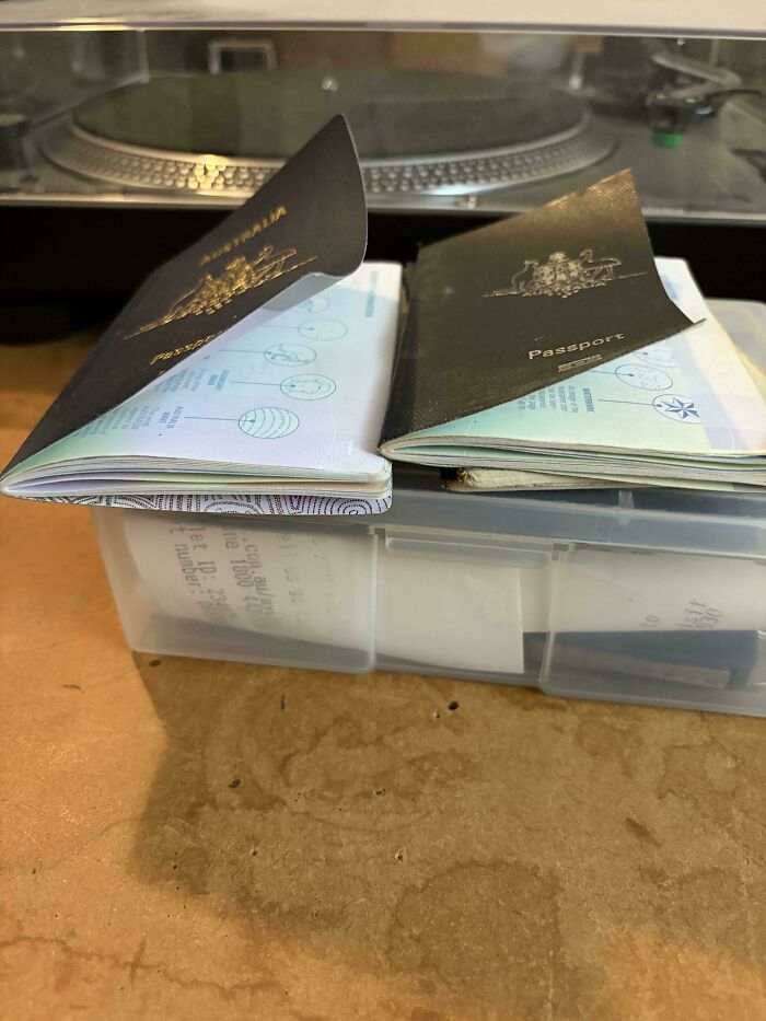 An Aussie post displaying two Australian passports, open to their first pages, resting on a clear container.
