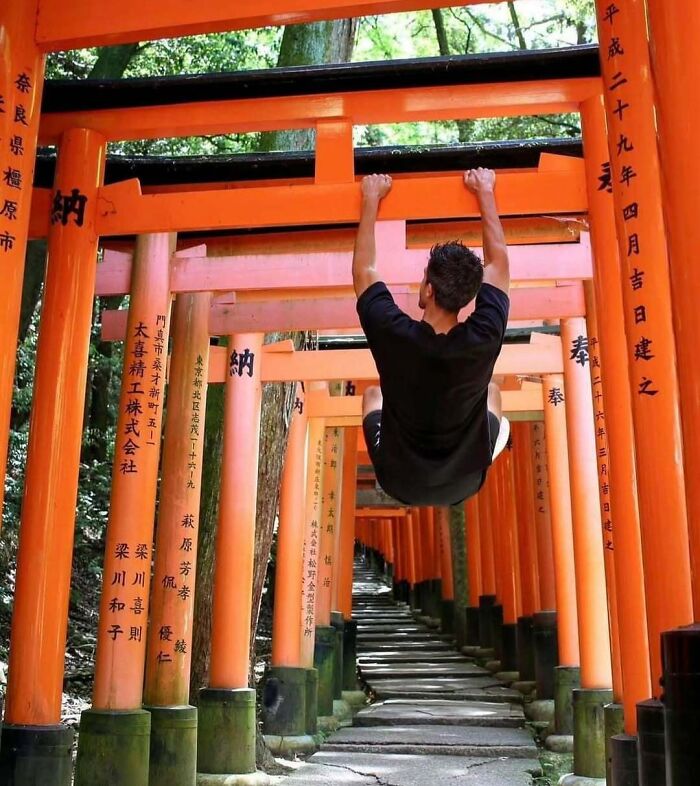 Tourist hanging on sacred torii gates, showing entitled behavior shamed online for disrespecting cultural landmarks.