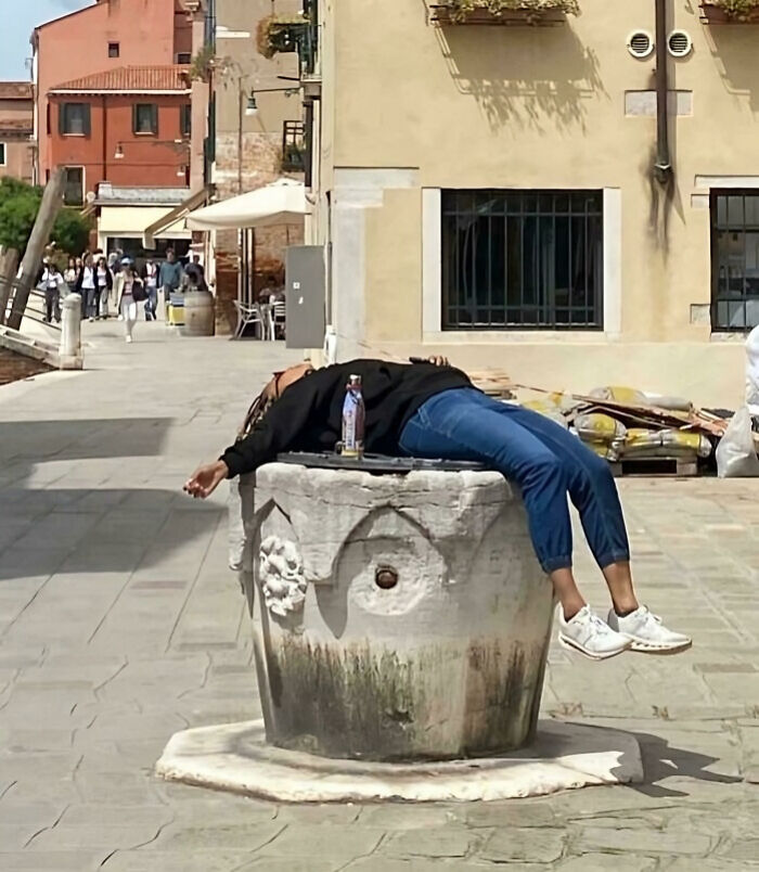 Tourist lying on historic monument in public area, displaying rude and entitled behavior caught in a popular online shame post.