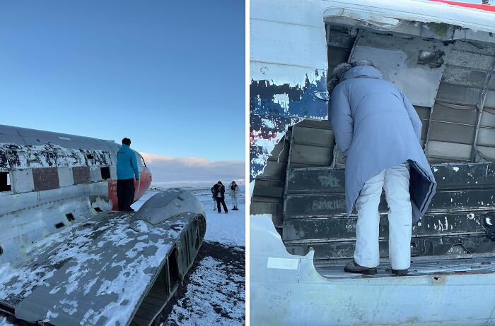 Tourists displaying entitled behavior while climbing and exploring a damaged airplane wreck in a snowy outdoor setting.