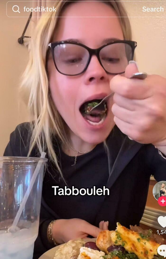 Woman eating tabbouleh at a table, showcasing cringy influencers who ignore rules and common sense online.