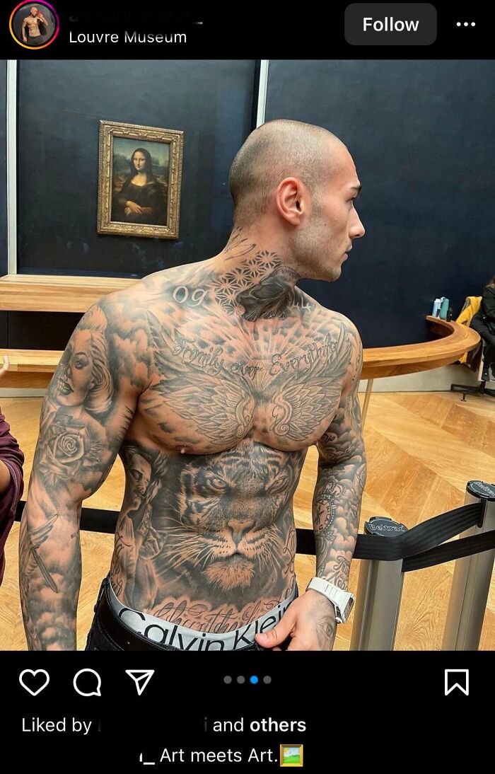 Influencer with extensive tattoos posing shirtless inside the Louvre Museum near the Mona Lisa painting.