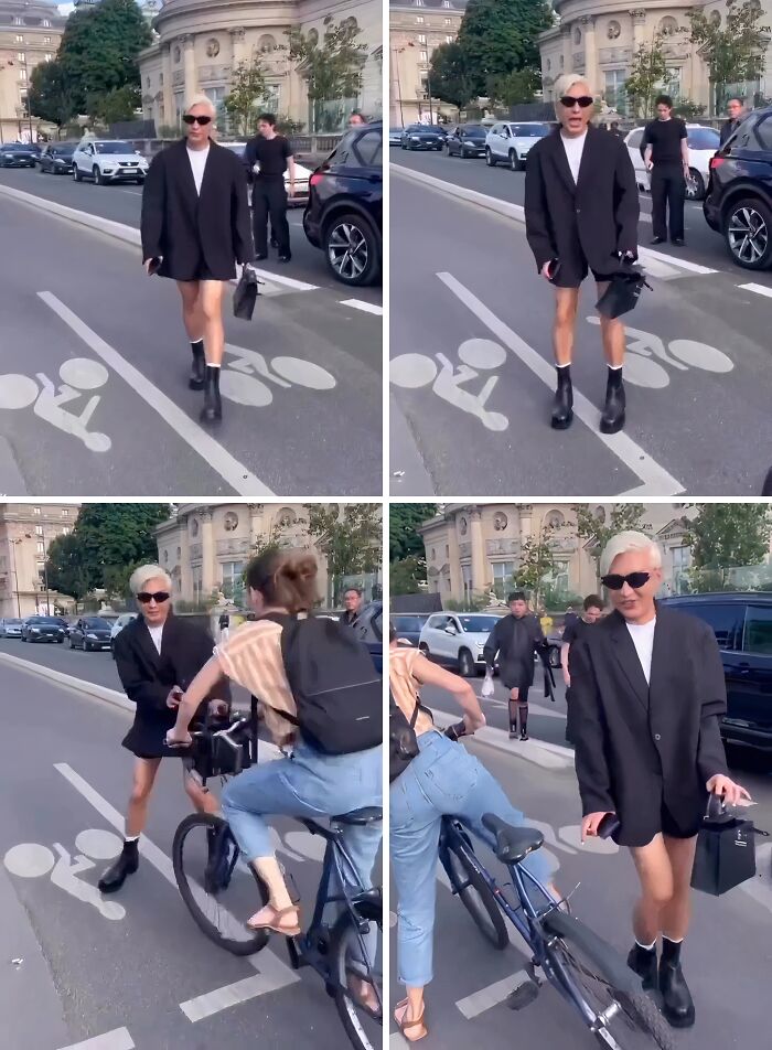 Influencer wearing oversized blazer and boots blocking bike lane, ignoring common sense and street rules in a city setting.
