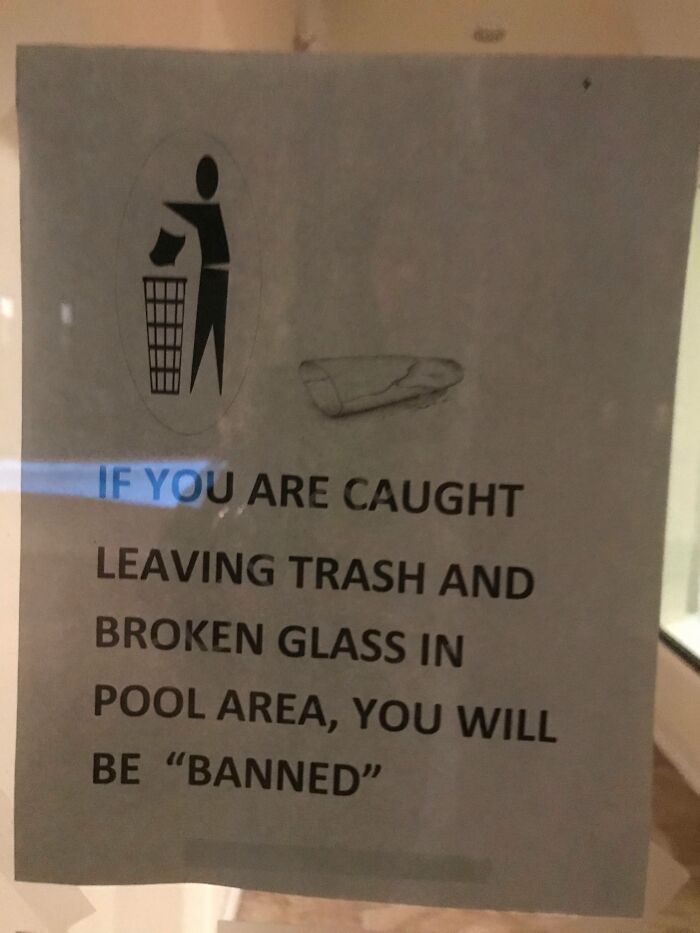 Sign with suspicious quotation marks around the word banned warning about trash and broken glass in pool area.