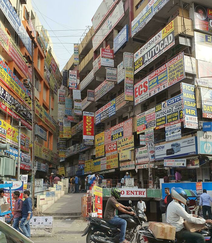 Crowded urban street packed with colorful advertisement signs and busy pedestrians