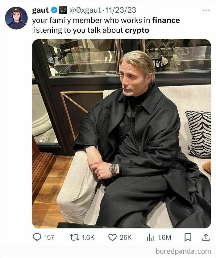 Man dressed in black sitting with a serious expression, reflecting white collar humor about finance and crypto conversations.