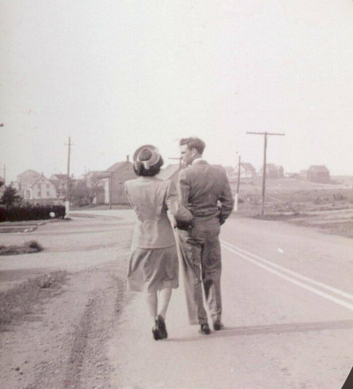 A candid old photo of a couple walking away on a road, revealing what the world looked like generations ago.