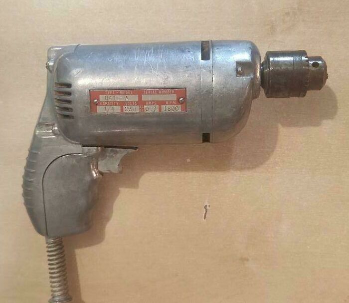 An old, metallic silver drill with a red data plate, showcasing a durable "Buy It For Life" purchase.