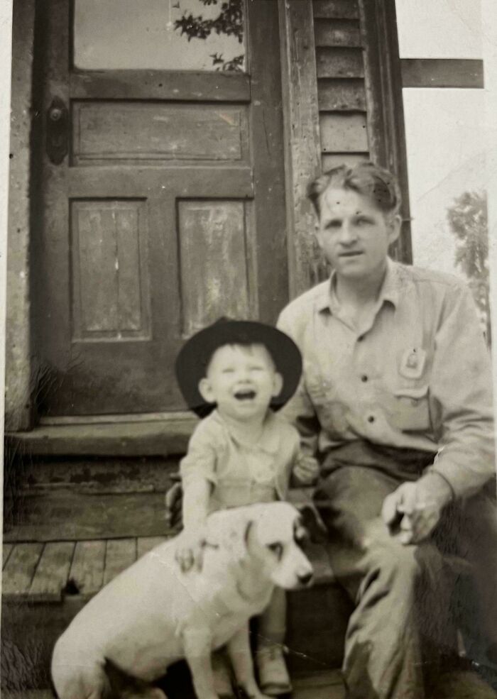 Vintage black and white photo of a man, child, and dog on porch, reflecting 109 photos from decades ago with timeless moments.