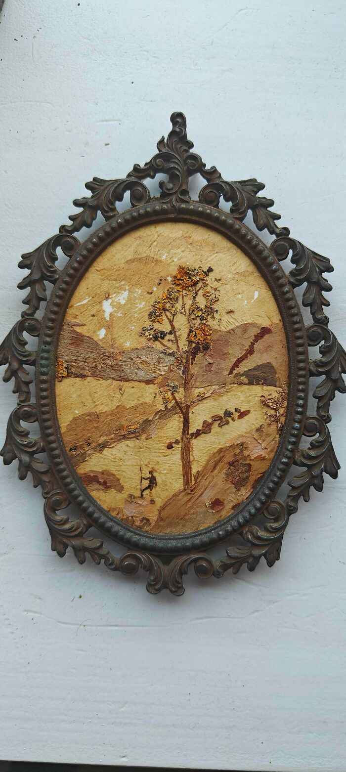 An oval framed antique artwork depicting a tree in a landscape, made from dried materials, a special stumbled upon piece.