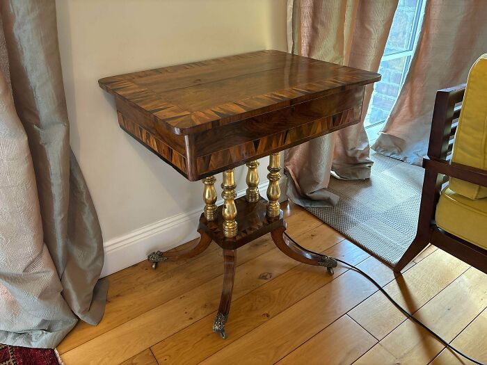 A remarkable antique wooden side table with ornate gold legs and intricate wood patterns, a special find.