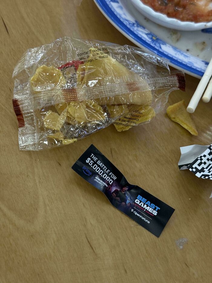 Fortune cookie broken and empty with promotional paper on wooden table