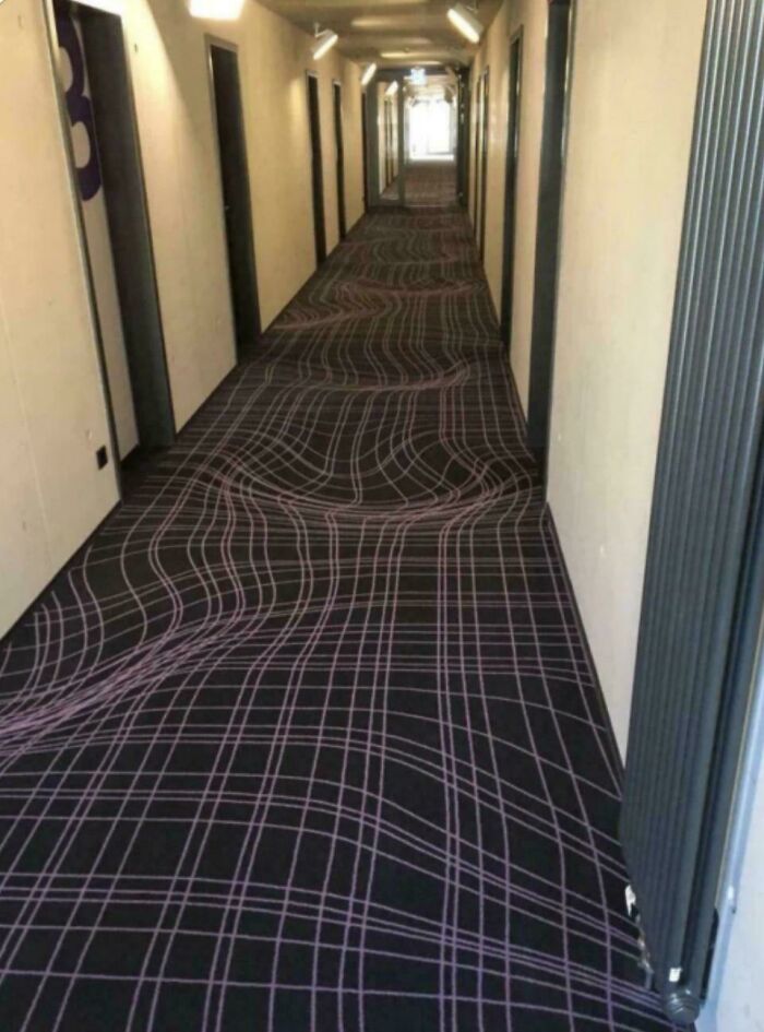 Hotel hallway with a warped carpet pattern creating a misleading and confusing photo that looks like a real-life glitch.