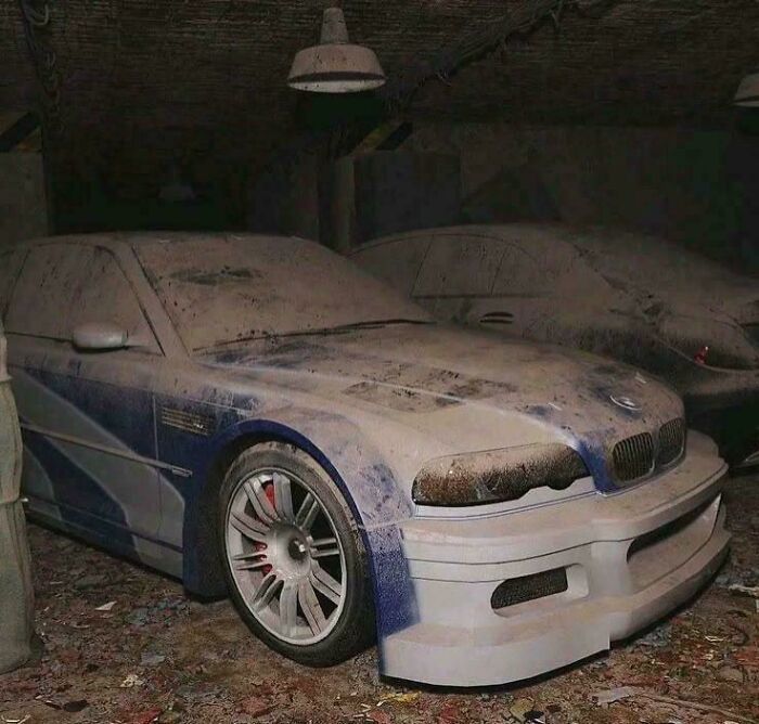 A peculiar photo of a dusty, abandoned blue and white race car in what looks like a storage unit.