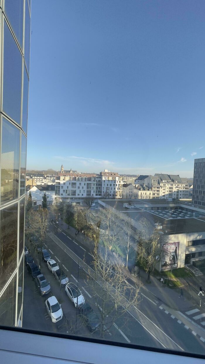 An aerial view of a city street with cars and buildings under a clear blue sky, a scene from the Not Interesting community.