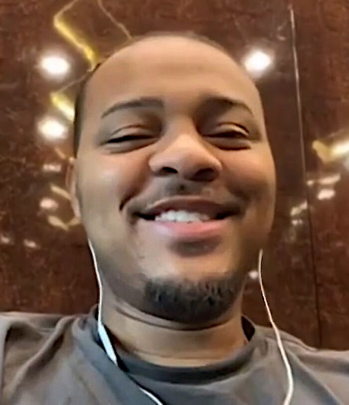 Bow Wow smiling, wearing earphones and a casual shirt, showcasing his relaxed and approachable personality.