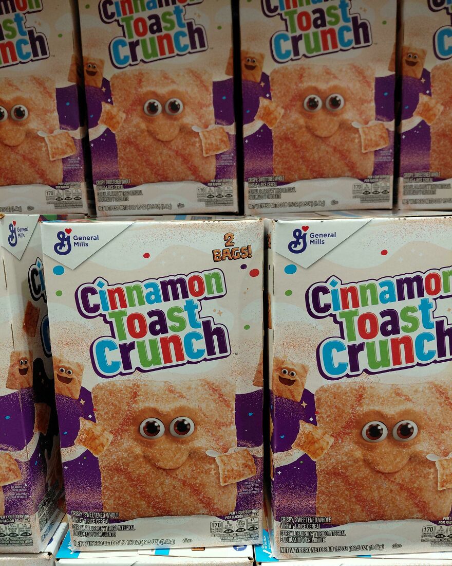 Boxes of Cinnamon Toast Crunch cereal stacked on a shelf showing a smiling cinnamon square with eyes, a weird and unexplainable sight.