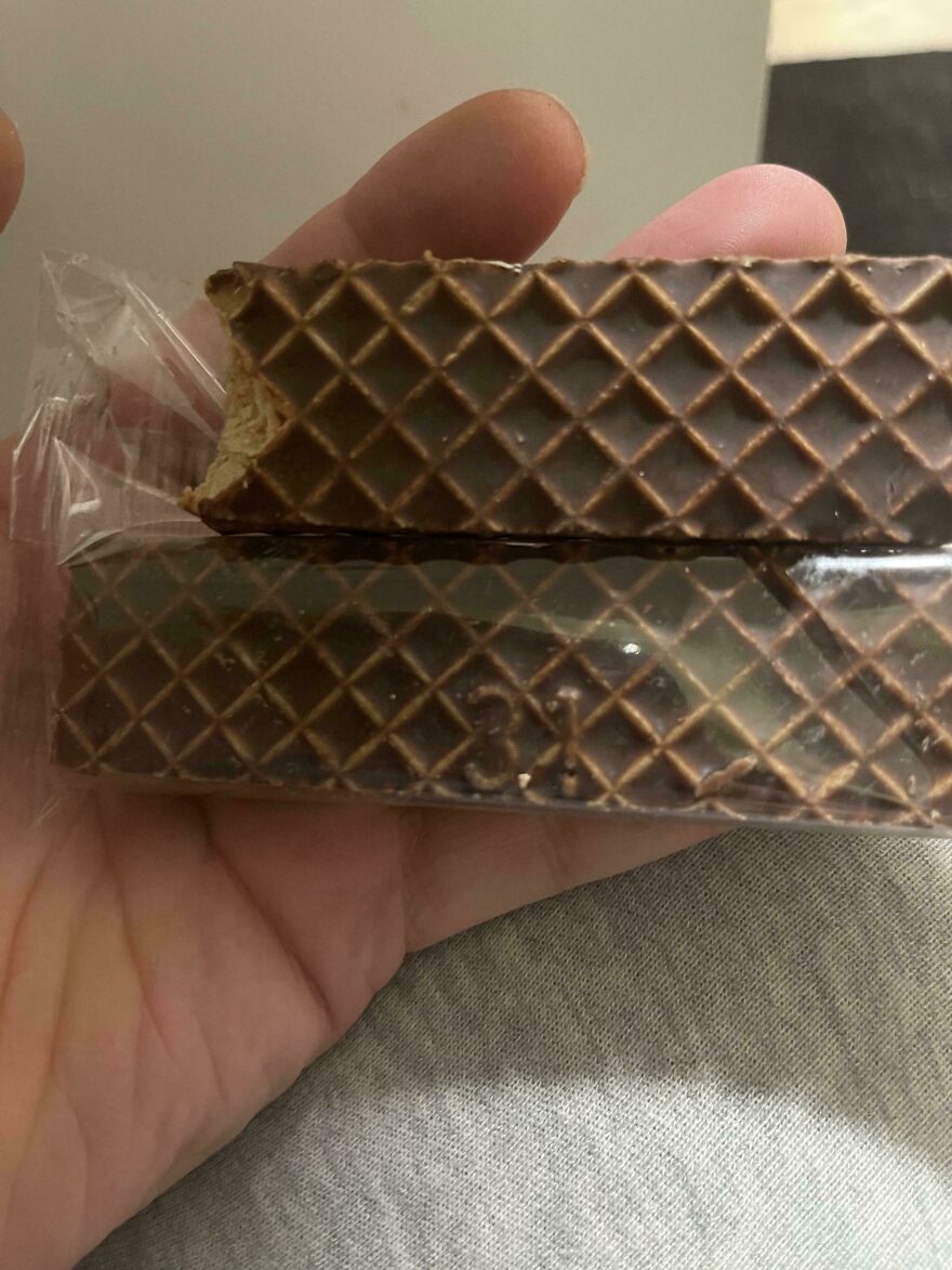 Close-up of two chocolate wafer bars held in hand showing unusual number 31 embedded in the design, weird unexplainable sight.