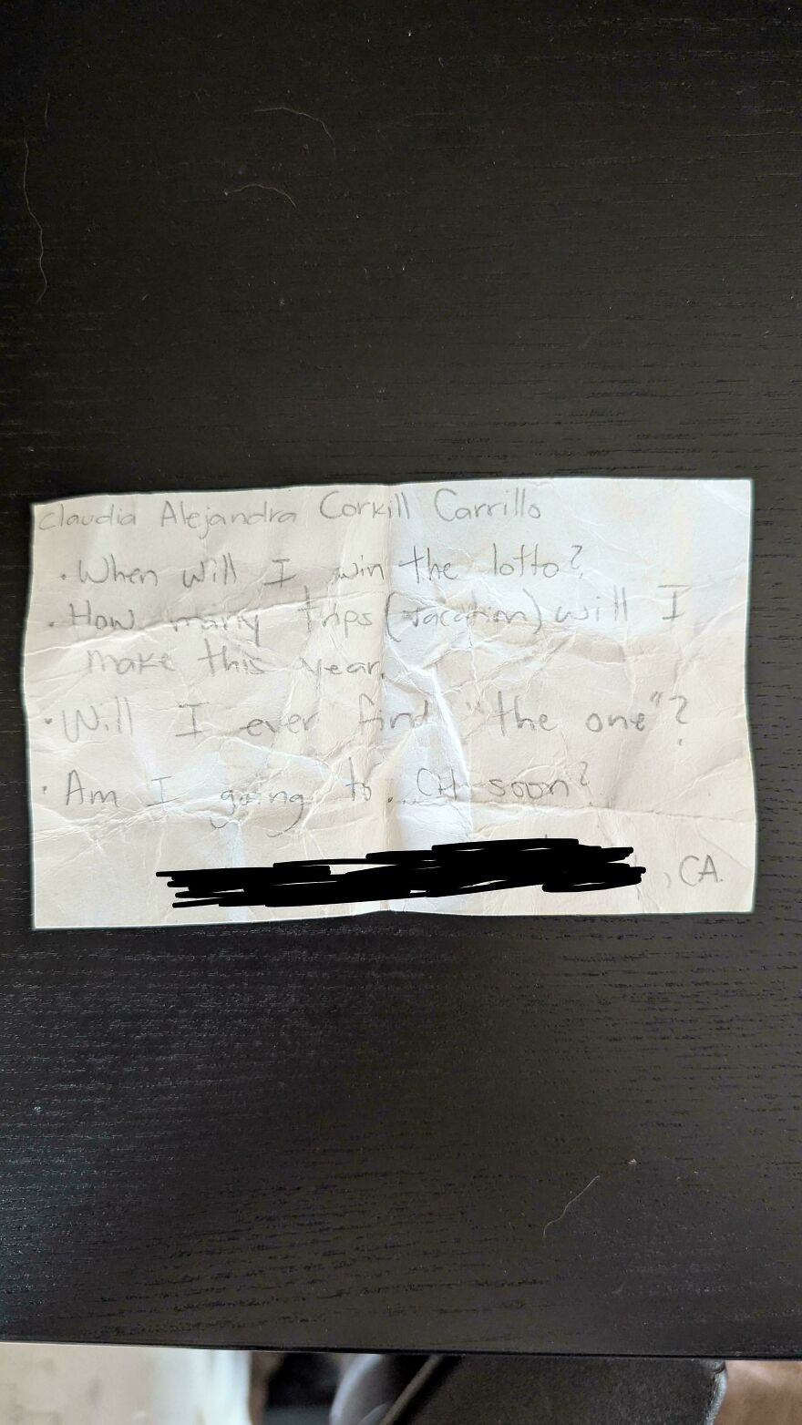 Crumpled note with handwritten questions about lottery, finances, love, and death, showing weird and unexplainable experiences.