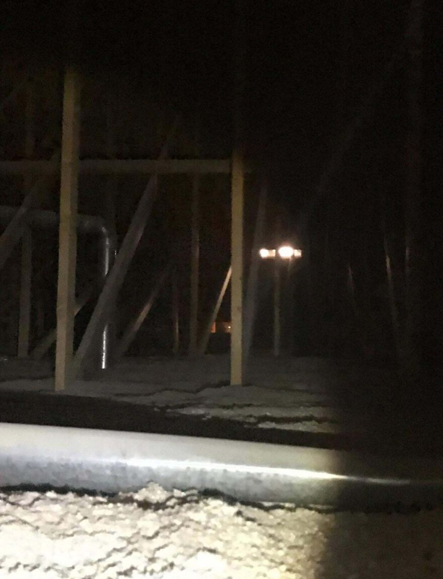 Dark attic with wooden beams and a mysterious glowing light in the background, showcasing weird unexplainable things experienced.
