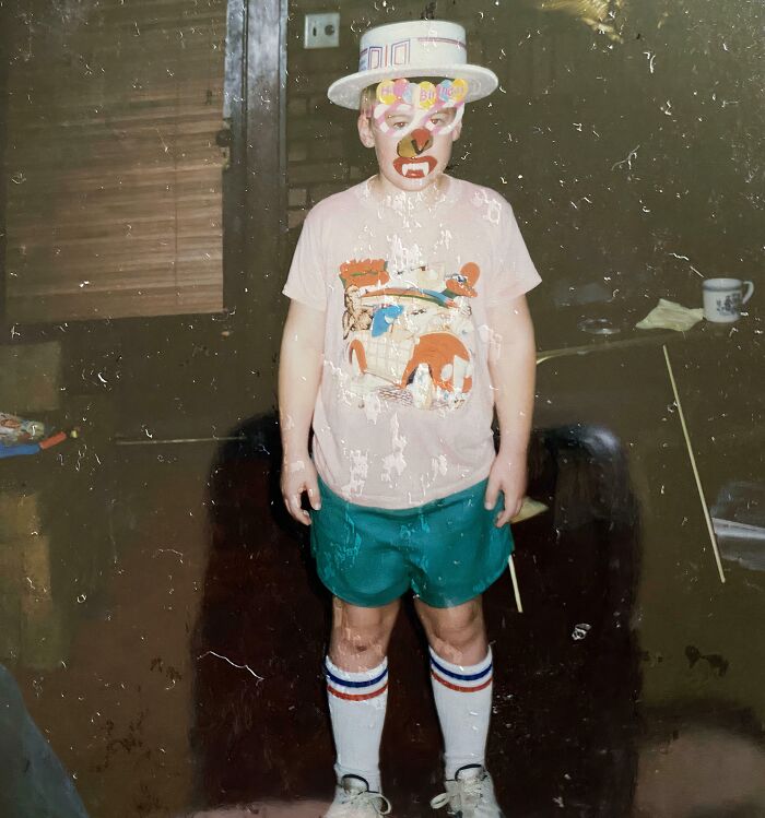 Child in awkward childhood pic wearing mismatched clothes and funny face paint, showcasing hilarious awkward childhood moments.