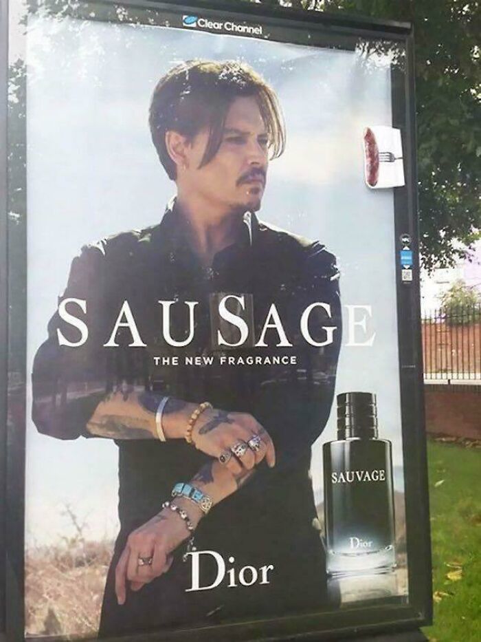 Outdoor Dior Sauvage fragrance ad altered with a fake sausage attached, an example of mild vandalism to cheer you up.