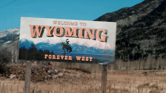 Welcome to Wyoming roadside sign with mountains backdrop, a key location for Yellowstone fans in the West.