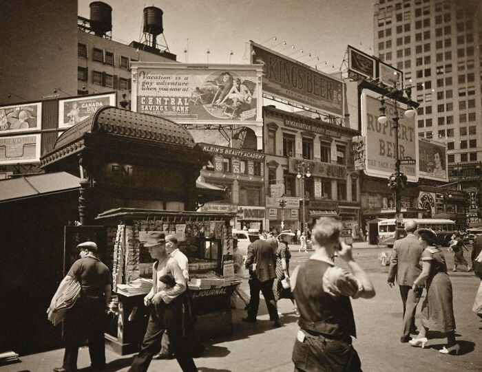 Vintage city street scene with people and old advertisements, illustrating strange moments in old photographs.