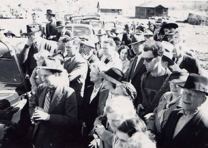 Crowd in old photograph wearing vintage clothing, illustrating strange moments often linked to time travel theories.