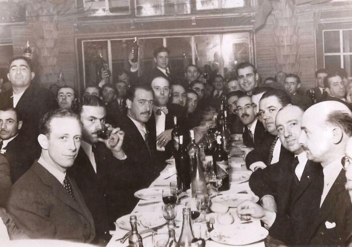 Group of men at a long table in an old photograph, showing strange details that suggest possible time travel mystery.