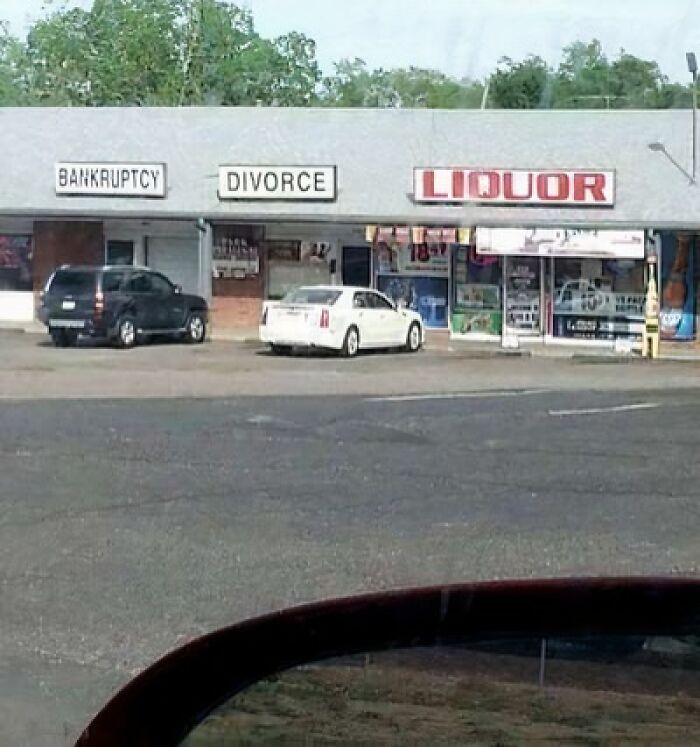 Storefront signs reading bankruptcy, divorce, and liquor, creating a humorous scene that makes people laugh or do a double take.