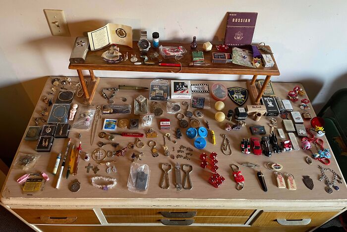 Collection of assorted vintage memorabilia and small items showcasing people's obsession turned into a collection on a wooden table.