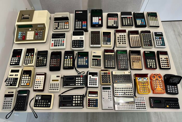 Collection of vintage calculators neatly arranged on a table, showcasing an impressive obsessed collection of retro devices.
