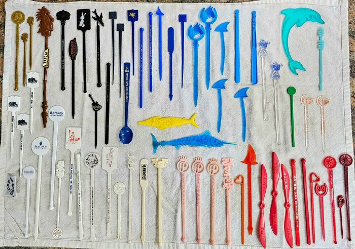 Collection of colorful drink stirrers and swizzle sticks neatly arranged, showcasing an obsession turned collection.